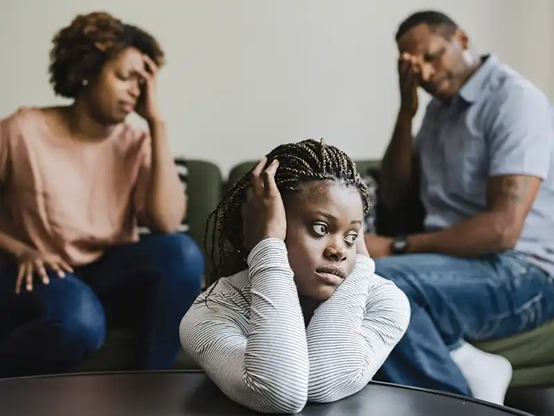 A young person with her parents in the background